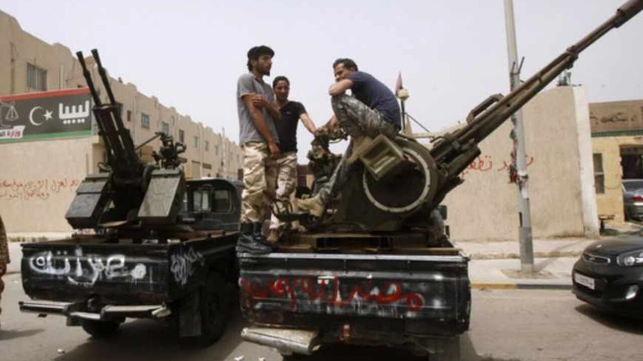 Members of armed revolutionaries stage a protest in front of the Libyan Justice Ministry in Tripoli April 30, 2013. Gunmen in pick-up trucks surrounded Libya's justice ministry Tuesday to step up demands for former aides to deposed dictator Muammar Gaddafi to be barred from senior government posts, Reuters witnesses said. Tension between the government and armed militias has been rising since authorities began a campaign to dislodge the gunmen from strongholds in the capital Tripoli to help curb lawlessness