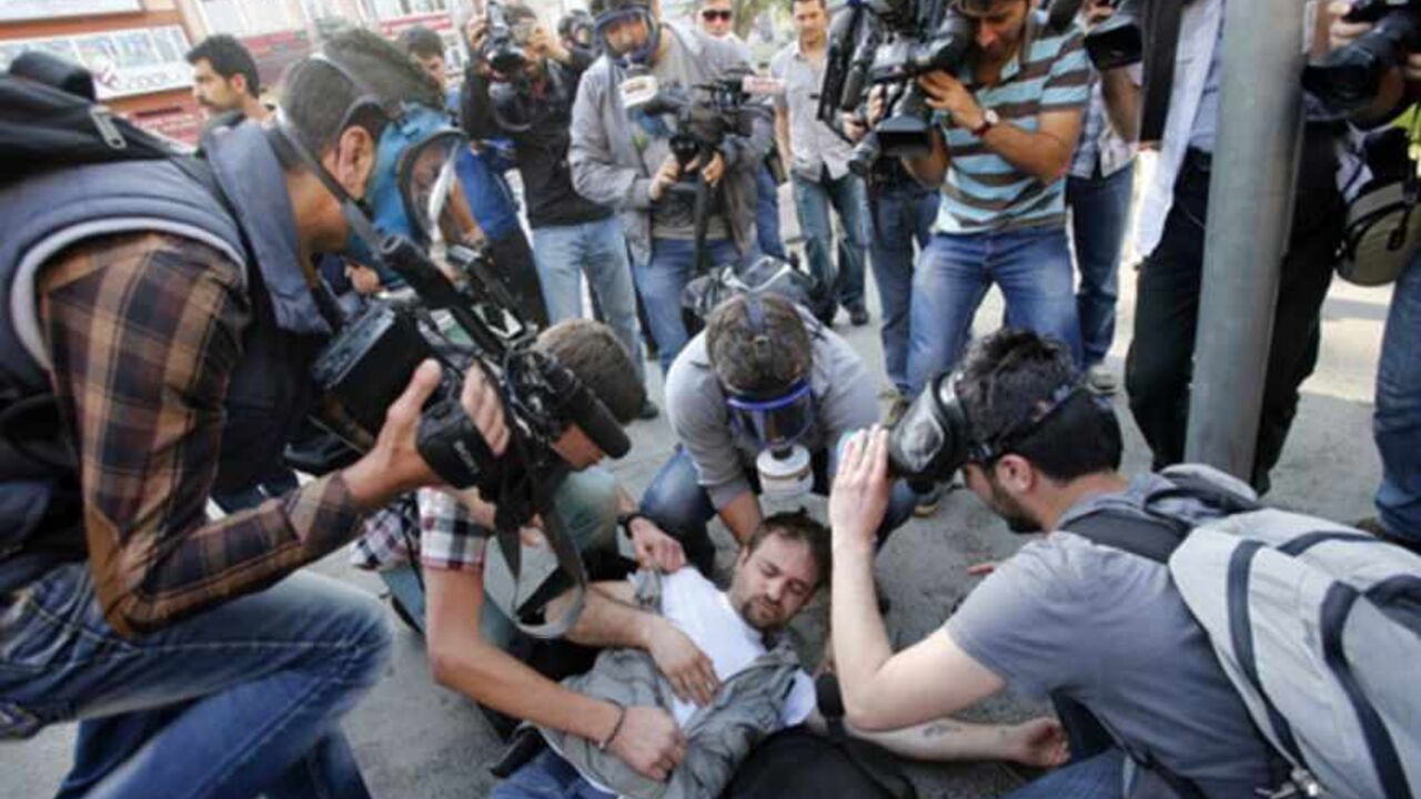 An injured journalist is filmed and helped by his colleagues during clashes between riot police and May Day protesters in central Istanbul May 1, 2013. Turkish riot police clashed with thousands of May Day protesters in Istanbul on Wednesday, firing water cannon and tear gas at crowds that tried to break through barricades to reach the city's main square, witnesses said. The incidents followed the pattern of recent years, when May Day demonstrations in Turkey's largest city have often been marked by clashes