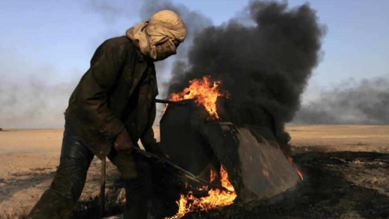 A man works at a makeshift oil refinery site in al-Mansoura village in Raqqa's countryside May 5, 2013. Many civilians in the village who lost their jobs due to the Syrian conflict are making a living by refining crude oil to extract useful fuel such as gasoline and kerosene for sale. Picture taken May 5, 2013. REUTERS/Hamid Khatib (SYRIA - Tags: CONFLICT ENERGY BUSINESS EMPLOYMENT) - RTXZIAG