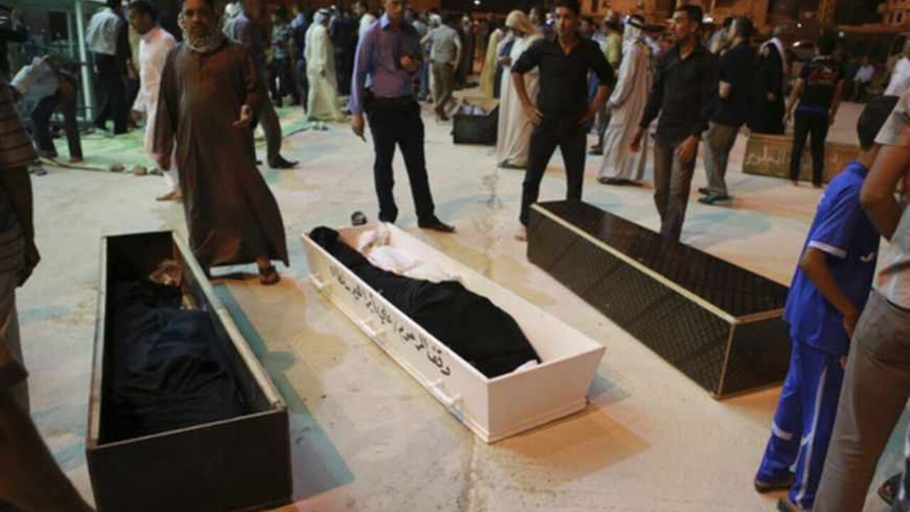 ATTENTION EDITORS - VISUAL COVERAGE OF SCENES OF INJURY OR DEATH

Mourners stand beside coffins of four members of a family killed in Basra bomb attacks, during a funeral in Najaf, around 160 km (99 miles) south of Baghdad May 20, 2013. More than 70 people were killed in a series of car bombings and suicide attacks targeting Shi'ite Muslims across Iraq on Monday, police and medics said, extending the worst sectarian violence since U.S. troops withdrew in December 2011. The attacks increased the number kil