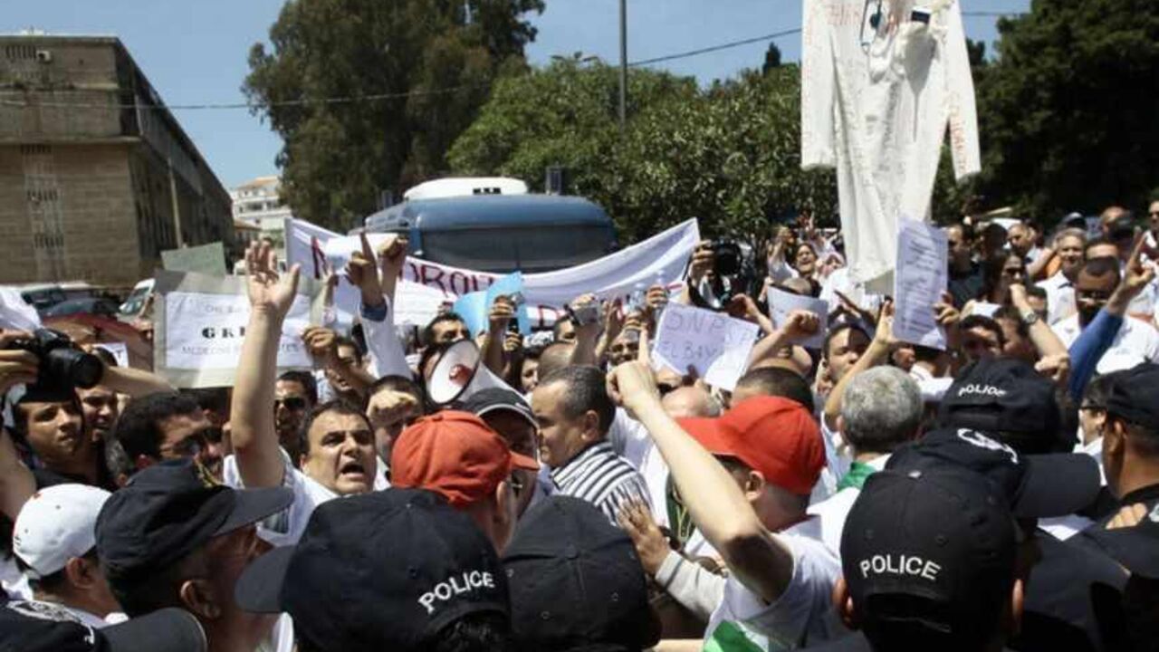 Policemen push medical staff during a protest rally near the Algerian Ministry of Health in Algiers May 8, 2013. Thousands of Algerian public sector doctors are on strike and have been holding regular protest rallies to demand an improvement in their terms of employment. REUTERS/Ramzi Boudina (ALGERIA - Tags: HEALTH BUSINESS EMPLOYMENT CIVIL UNREST) - RTXZF33