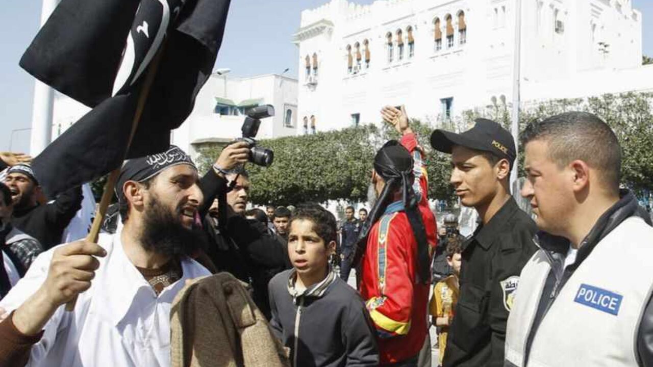 A salafist protester (L) gestures to riot police during a protest demanding for the inclusion of Islamic Law in the constitution in Tunis March 23, 2012.  REUTERS/Zoubeir Souissi (TUNISIA - Tags: POLITICS RELIGION CIVIL UNREST) - RTR2ZRUE