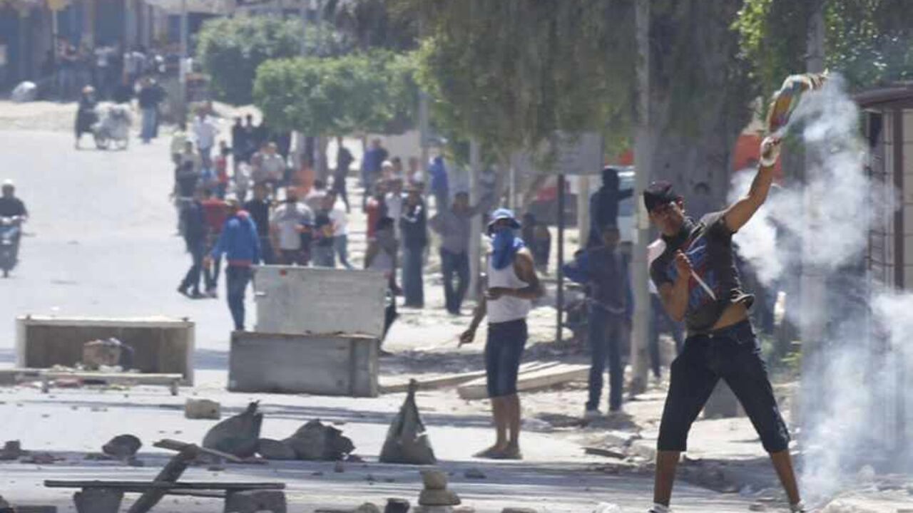 Supporters of Islamist group Ansar al-Sharia clash with riot police at Hai al Tadamon in Tunis May 19, 2013. Supporters of the hardline Islamist group clashed with Tunisian police in two cities on Sunday after the government banned its annual rally and the regional arm of al Qaeda urged it to stand firm against the authorities.  REUTERS/Anis Mili  (TUNISIA - Tags: CIVIL UNREST POLITICS RELIGION) - RTXZSQU