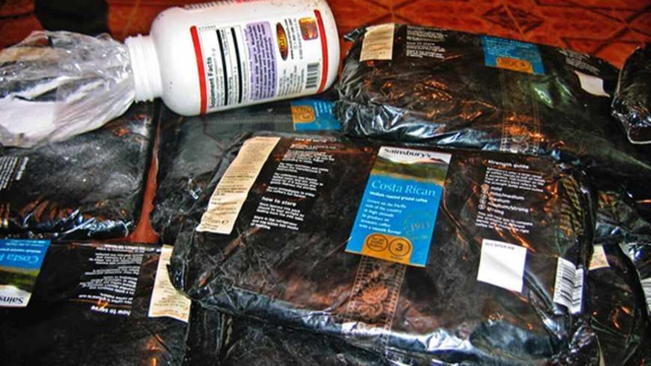 Iraqi police display drugs which were seized in the southern city of Kerbala, 100 kms (62 miles) south of Baghdad September 6, 2005. The Major Crime Unit in Kerbala arrested four men attempting to smuggle over 20 kgs (44 pounds) of cocaine, heroin and hashish into Iraq, the latest in a string of recent seizures. The heroin was hidden in bags which were labelled as Costa Rican coffee. Police put the value of the drugs at around 280 million Iraqi dinars (about $1,930,000). REUTERS/Mshatq Mohamad  RCS/VP - RTR