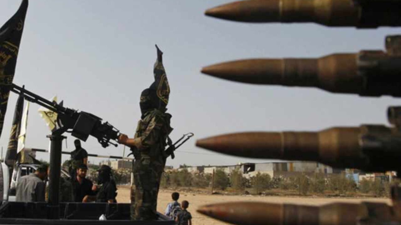 An Islamic Jihad militant rides on the back of a pick-up truck during a parade to mark the 25th anniversary of the movement's foundation in Rafah in the southern Gaza Strip October 2, 2012. REUTERS/Ahmed Zakot (GAZA - Tags: POLITICS CIVIL UNREST TPX IMAGES OF THE DAY) - RTR38PCW