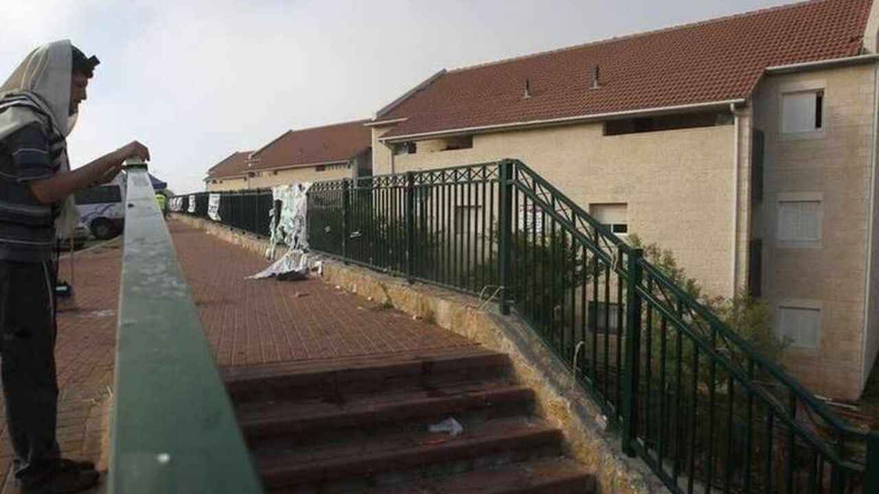 A Jewish settler recites morning prayers before some families began moving out of the Ulpana neighbourhood of the Beit El settlement near the West Bank city of Ramallah June 26, 2012. Settlers on Tuesday began moving out of apartment blocs that Israel's Supreme Court ruled had been built illegally on Palestinian-owned land, after reaching an agreement with the government to go quietly. REUTERS/Baz Ratner (WEST BANK - Tags: POLITICS RELIGION TPX IMAGES OF THE DAY) - RTR34608