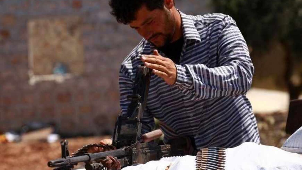 A Free Syrian Army member inspects his weapon beside a checkpoint to siege the Kurdish city of Afrin, which is under the control of the Kurdistan Workers' Party (PKK), in the Aleppo countryside June 30, 2013. REUTERS/Hamid Khatib (SYRIA - Tags: POLITICS CIVIL UNREST CONFLICT) - RTX117H8