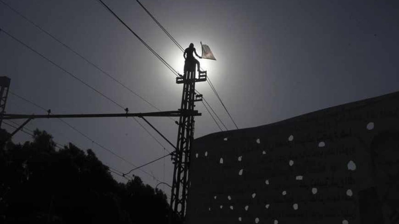 A protester opposing Egyptian President Mohamed Mursi stands on top of an electric tram column as he waves an Egyptian flag during a protest in front of El-Thadiya presidential palace in Cairo June 30, 2013. Millions of Egyptians flooded into the streets on the first anniversary of Islamist President Mursi's inauguration on Sunday to demand that he resign in the biggest challenge so far to rule by his Muslim Brotherhood.  REUTERS/Amr Abdallah Dalsh  (EGYPT - Tags: POLITICS CIVIL UNREST) - RTX117Z3