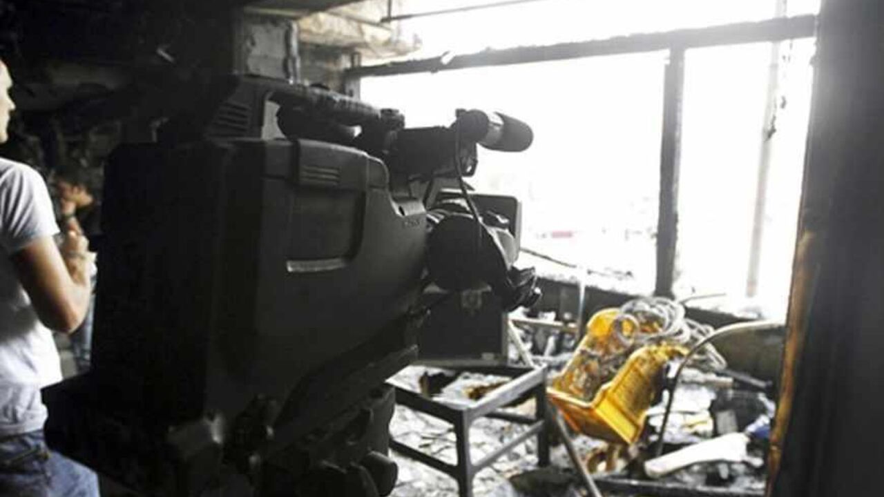 People are seen in a burnt studio of Al Jazeera TV network, at Tahrir Square in Cairo November 21, 2012. The studio used by the Al Jazeera TV network was set on fire on Wednesday in central Cairo as security forces and protesters fought in the streets of the Egyptian capital for a third day. REUTERS/Mohamed Abd El Ghany (EGYPT - Tags: POLITICS CIVIL UNREST MEDIA) - RTR3APPP