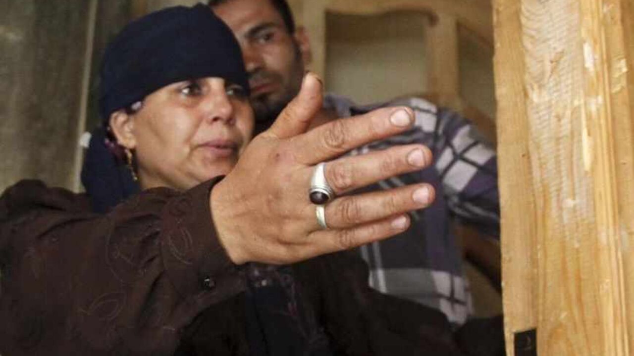 Kasbana Hassan gestures inside her burnt out house, where four Egyptian Shi'ites were killed, in the suburb of Zawiyat Abu Musallem, on the outskirts of Cairo, June 24, 2013. Egypt's government promised "exemplary punishment" on Monday after the mob killing of four Shi'ite Muslims near Cairo raised fears of wider sectarian bloodshed at a time of grave national crisis. In Sunday's violence in the suburb of Zawiyat Abu Musallem, in sight of the Giza pyramids, a crowd ransacked and torched the house of a famil