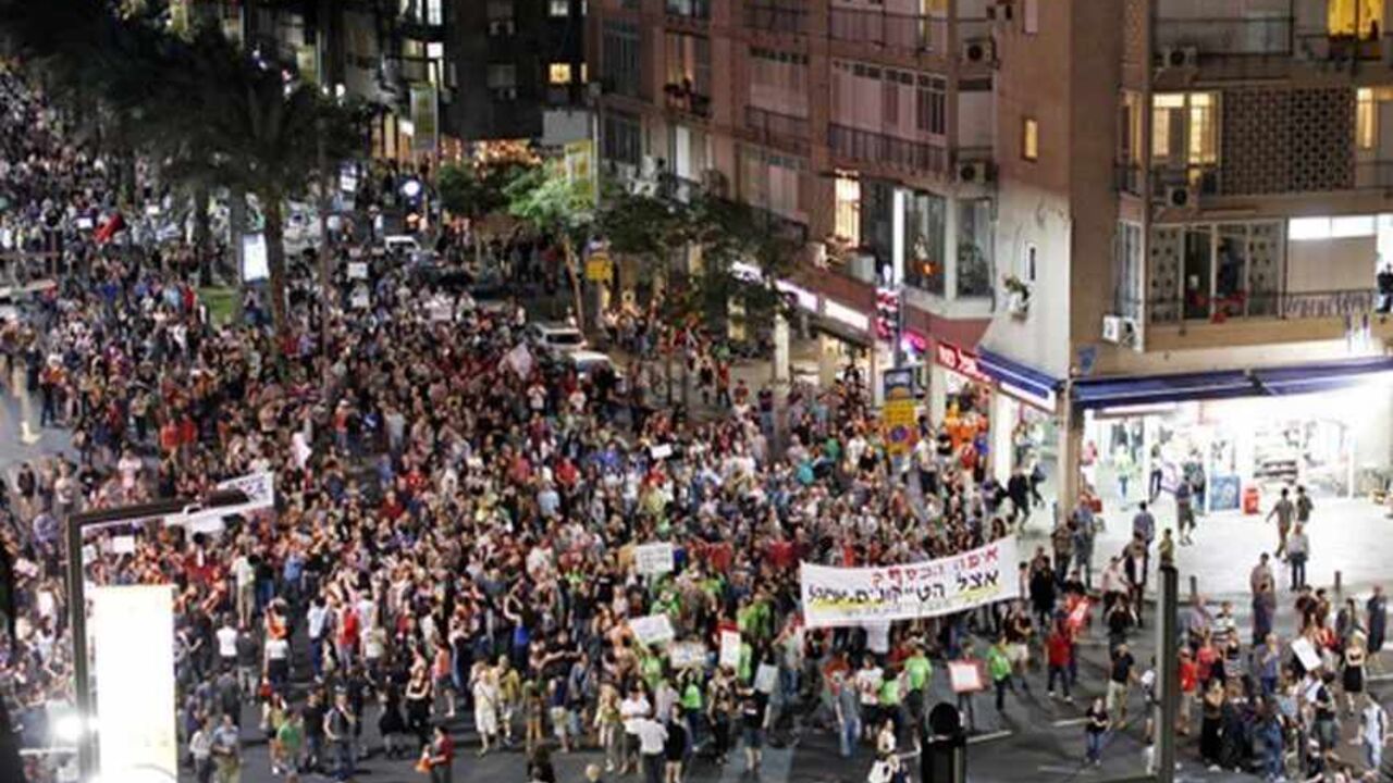 Protesters demonstrate against new austerity measures set to be included in the 2013-2014 national budget at a main junction in Tel Aviv May 11, 2013. Between 2,000 and 3,000 people demonstrated against the measures, which will be discussed by the Israeli cabinet on Monday. REUTERS/ Amir Cohen (ISRAEL - Tags: BUSINESS POLITICS CIVIL UNREST) - RTXZJ74