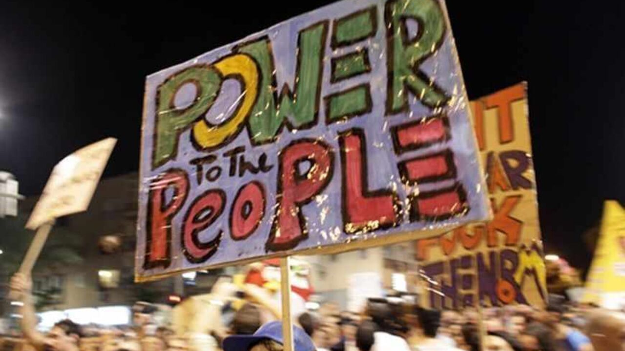 A man holds a sign during a demonstration calling for lower living costs and social justice in Tel Aviv September 3, 2011. Hundreds of thousands marched on Saturday for lower living costs in the largest such rally in Israel's history, bolstering a social change movement and mounting pressure on Prime Minister Benjamin Netanyahu to take on economic reform.  REUTERS/Darren Whiteside (ISRAEL - Tags: CIVIL UNREST TPX IMAGES OF THE DAY) - RTR2QR98