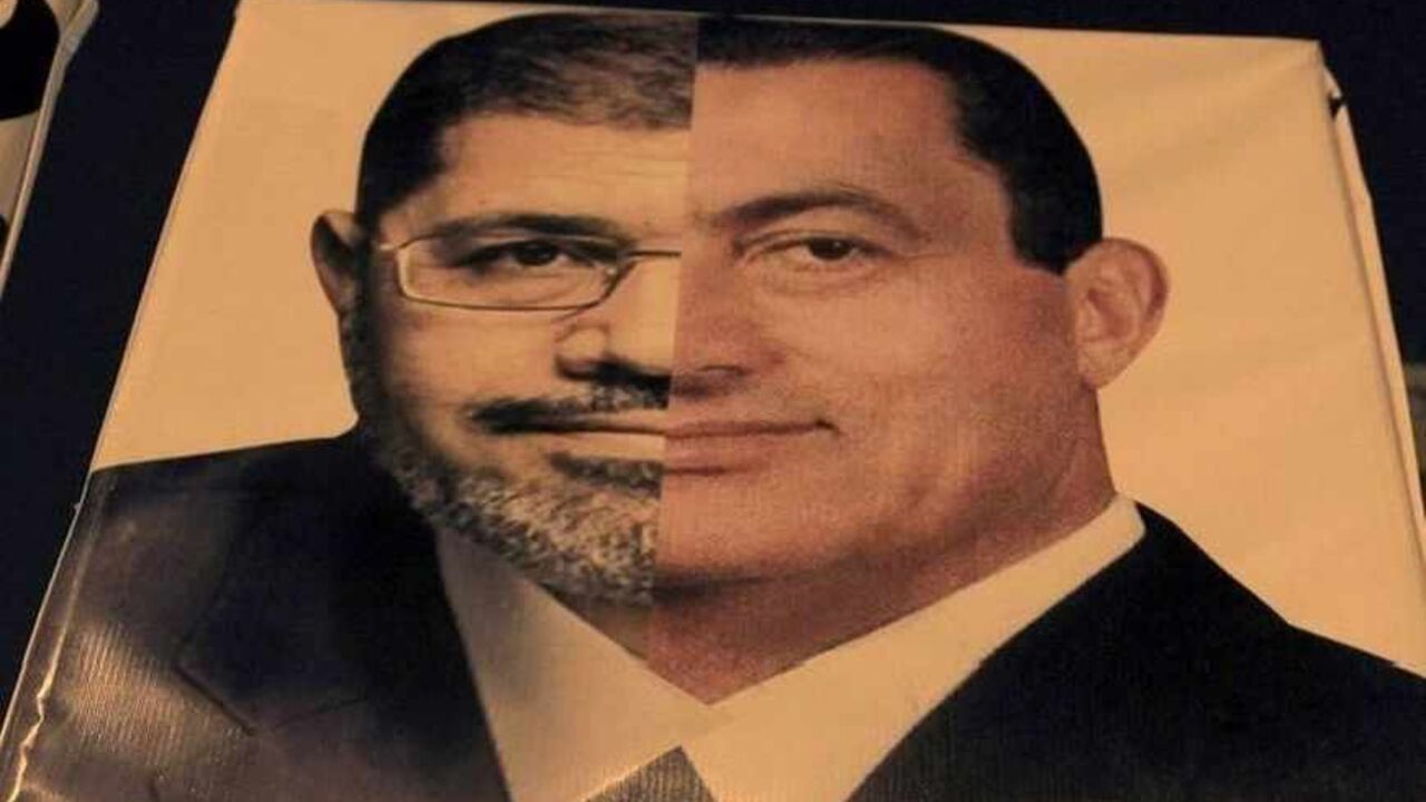 An Egyptian holds a banner against President Mohammed Morsi, comparing him with Hosni Mubarak, in Cairo October 19, 2012. Hundreds of Egyptian liberals and leftists rallied in Cairo on Friday to demand that Islamists stop foisting their ideas upon society, saying the days of one-party rule ended with the overthrow of Hosni Mubarak.  REUTERS/Mohamed Abd El Ghany (EGYPT - Tags: POLITICS CIVIL UNREST) - RTR39C52