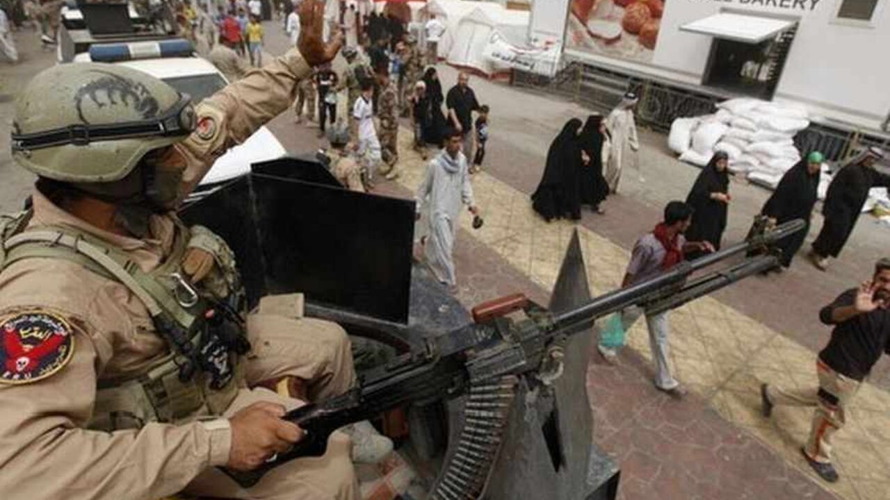 A soldier waves to pilgrims marching towards Imam Moussa al-Kadhim shrine in Baghdad's Kadhimiya district June 4, 2013. Every year, thousands of Shi'ite pilgrims gather at the shrine to commemorate the death of Imam Moussa al-Kadhim, one of the 12 imams of Shi'ite, who was imprisoned for four years and poisoned by the then ruler Harun al-Rashid in 795 AD. REUTERS/Saad Shalash (IRAQ - Tags: RELIGION MILITARY) - RTX10B2B