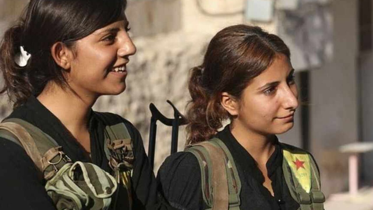 Kurdish fighters from the Popular Protection Units (YPG), wearing vests with the YPG logo, stand along a street in Aleppo's Sheikh Maqsoud neighborhood, June 19, 2013. Kurdish fighters from the Popular Protection Units (YPG) joined the Free Syrian Army to fight against forces loyal to Syria's President Bashar al-Assad. Picture taken June 19, 2013. REUTERS/Nour Kelze (SYRIA - Tags: POLITICS CIVIL UNREST CONFLICT) - RTX10UJS