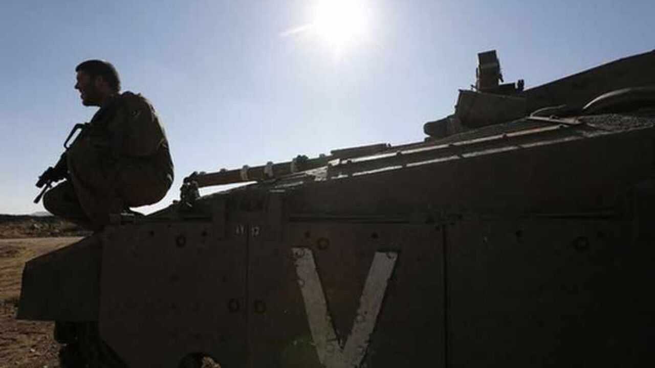 An Israeli soldier sits atop a tank near the Quneitra border crossing between Israel and Syria, on the Israeli-occupied Golan Heights July 3, 2013. Israel is bolstering its forces on the once-quiet frontier with Syria where it believes Lebanese Hezbollah militants are preparing for the day when they could fight Israel. Picture taken July 3, 2013. REUTERS/Baz Ratner (MILITARY POLITICS) - RTX11IMD