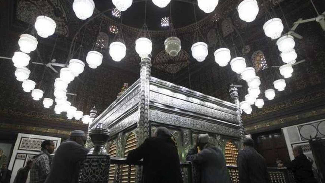 People pray at the shrine of Prophet Mohammed's grandson Hussein ibn Ali at the Al-Hussein mosque, named after the grandson, before Iran's President Mahmoud Ahmadinejad's visit to the mosque in old Cairo February 5, 2013. Ahmadinejad was both kissed and scolded on Tuesday when he began the first visit to Egypt by an Iranian president since Tehran's 1979 Islamic revolution. The trip was meant to underline a thaw in relations since Egyptians elected an Islamist head of state, President Mohamed Mursi, last Jun
