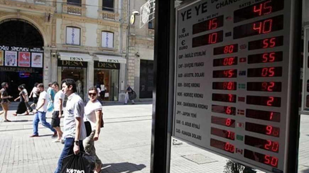 People walk past a display board at a currency exchange office in Istanbul July 11, 2013. Turkey's central bank faced calls on Thursday to raise interest rates to steady the embattled lira despite political pressure from Prime Minister Tayyip Erdogan to keep rates low - a dilemma which could put the bank's credibility at stake. REUTERS/Osman Orsal (TURKEY - Tags: BUSINESS) - RTX11JW3