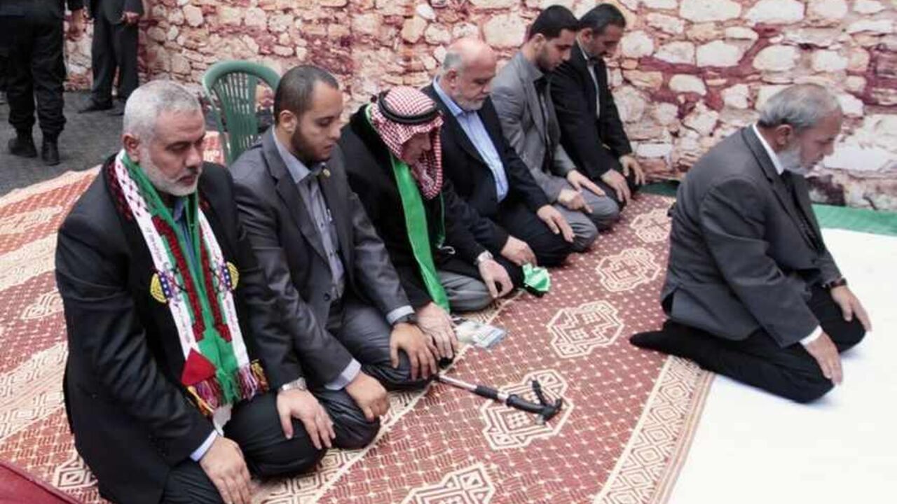 Senior Hamas leaders Ismail Haniyeh (L) and Mahmoud Al-Zahar (R) pray at the stage during a rally marking the 25th anniversary of the founding of Hamas, in Gaza City December 8, 2012. Hamas leader Khaled Meshaal, in an uncompromising speech during his first ever visit to Gaza after decades of exile, told a mass rally on Saturday he would never recognise Israel and pledged to "free the land of Palestine inch by inch".  REUTERS/Ahmed Jadallah (GAZA - Tags: POLITICS ANNIVERSARY CIVIL UNREST RELIGION) - RTR3BCZ