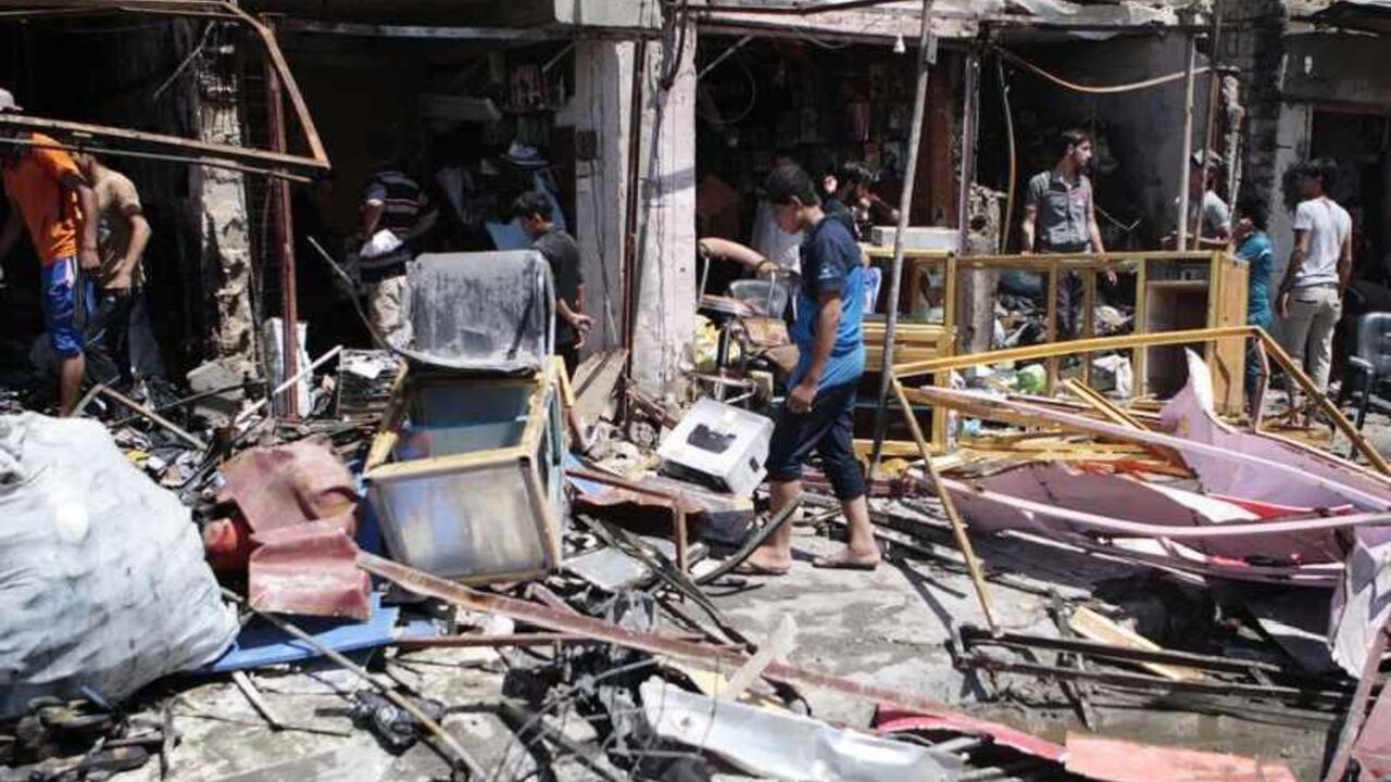 Residents inspect the site of a car bomb attack in Basra, 420 km (260 miles) southeast of Baghdad, July 29, 2013. One car bomb went off in a busy popular market north of the southern oil hub city of Basra on Monday, killing at least two civilians and wounding 10 others, police and medical sources said. REUTERS/Stringer (IRAQ - Tags: CIVIL UNREST) - RTX123II