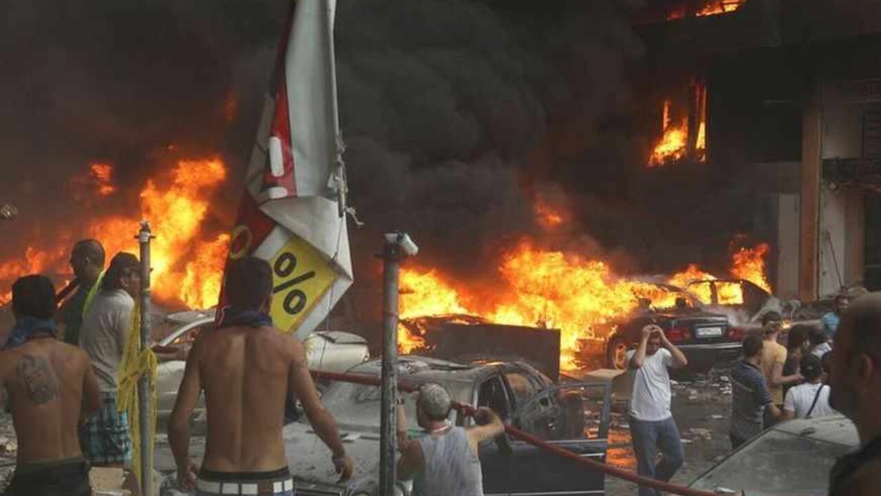People gather around the site of an explosion in Beirut's southern suburbs, August 15, 2013. Twenty people were killed in the explosion which struck the southern Beirut stronghold of Lebanon's militant Hezbollah group on Thursday, a security source said. An army statement said the cause of the explosion was a car bomb. The blast engulfed several vehicles in flames and trapped many people in nearby buildings which were damaged in the explosion. REUTERS/ Hasan Shaaban (LEBANON - Tags: CIVIL UNREST POLITICS) -