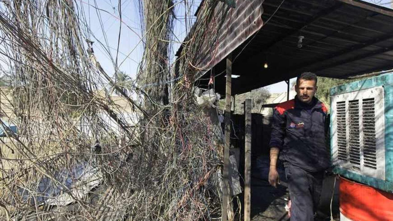 An electrician walks past wires connected to a local generator in Baghdad January 23, 2011. Iraq is slowly getting back on its feet after decades of war and economic sanctions, but a chronic power shortage is hobbling the development of local industry just when it is needed most. An unemployment rate that some officials say runs at 30 percent represents not just an economic challenge but also provides muscle for a lingering insurgency as the sectarian warfare unleashed after the 2003 U.S.-led invasion fades