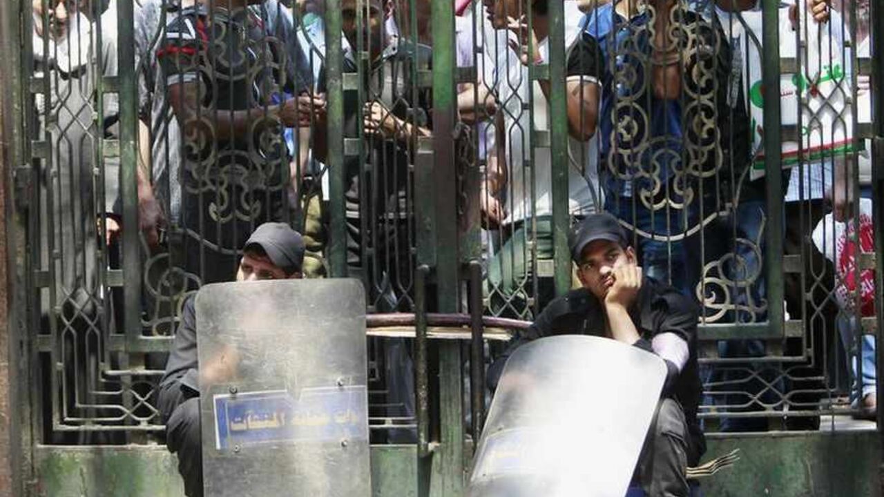 Police officers guard a gate to al-Fath mosque, where demonstrators in support of ousted Egyptian President Mohamed Mursi wait inside, at Ramses Square in Cairo August 17, 2013.  Gunmen and members of the Egyptian security forces exchanged fire on Saturday in a Cairo square where dozens of supporters of deposed Islamist President Mohamed Mursi were shot dead the day before, Reuters journalists said. Footage broadcast by the privately-owned CBC station appeared to show someone firing from the minaret of the 