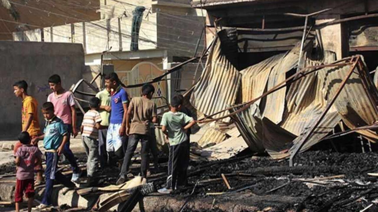 Children look at the site of a bomb attack, one day after the blast, in the center of Baquba, 65 km (40 miles) northeast of Baghdad, August 15, 2013. Twin roadside bombs exploded in the Iraqi city of Baquba on Wednesday, killing 14 people and wounding 26, police said, the latest in a wave of summer attacks. REUTERS/Mohammed Adnan (IRAQ - Tags: POLITICS CIVIL UNREST SOCIETY) - RTX12M8P