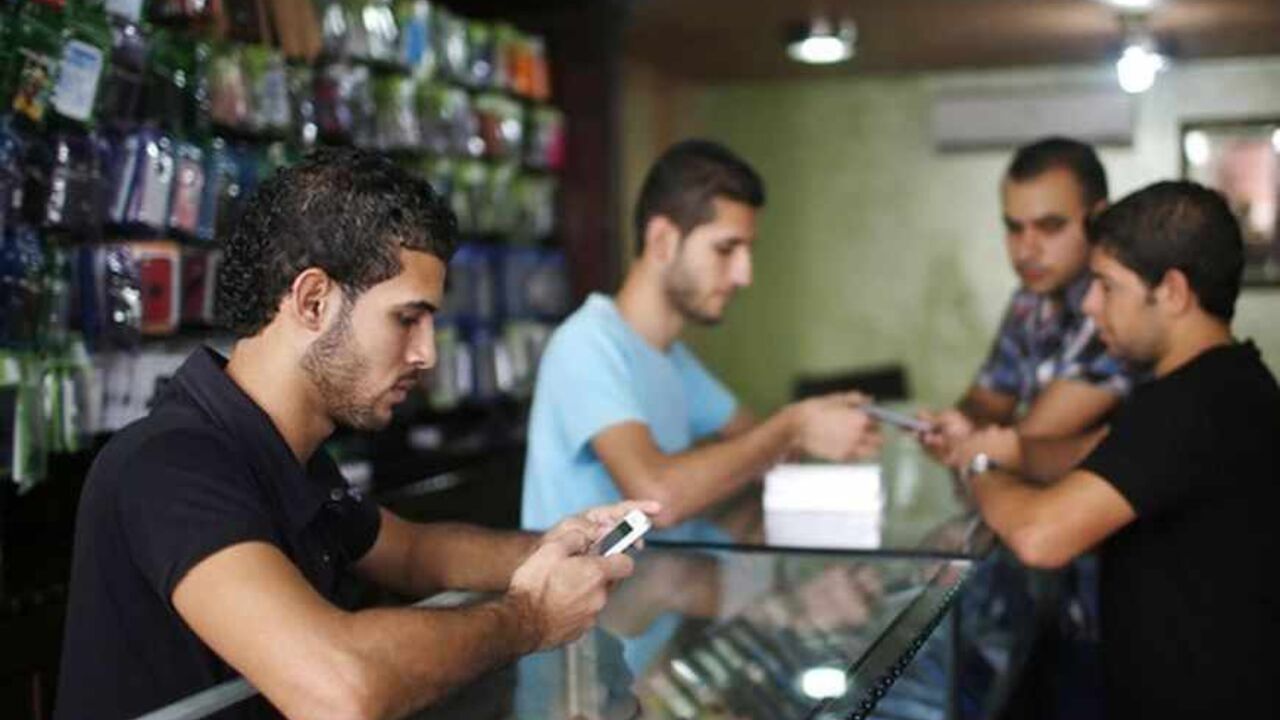 A Palestinian salesperson holds Apple's new iPhone 5 at a mobile phone store in Gaza City October 16, 2012. Apple's new iPhone 5 is selling well in the Gaza Strip despite inflated prices, reaching the Palestinian enclave via smuggling tunnels even before high-tech hub Israel next door.   REUTERS/Mohammed Salem (GAZA - Tags: POLITICS SCIENCE TECHNOLOGY BUSINESS SOCIETY TELECOMS) - RTR3970R