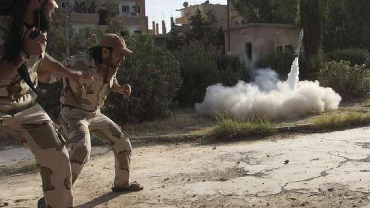 Members of the Free Syrian Army react as they fire a home-made rocket towards forces loyal to the Syrian regime in Deir al-Zor, June 16, 2013. Picture taken June 16, 2013. REUTERS/Khalil Ashawi (SYRIA - Tags: CONFLICT) - RTX10QLQ