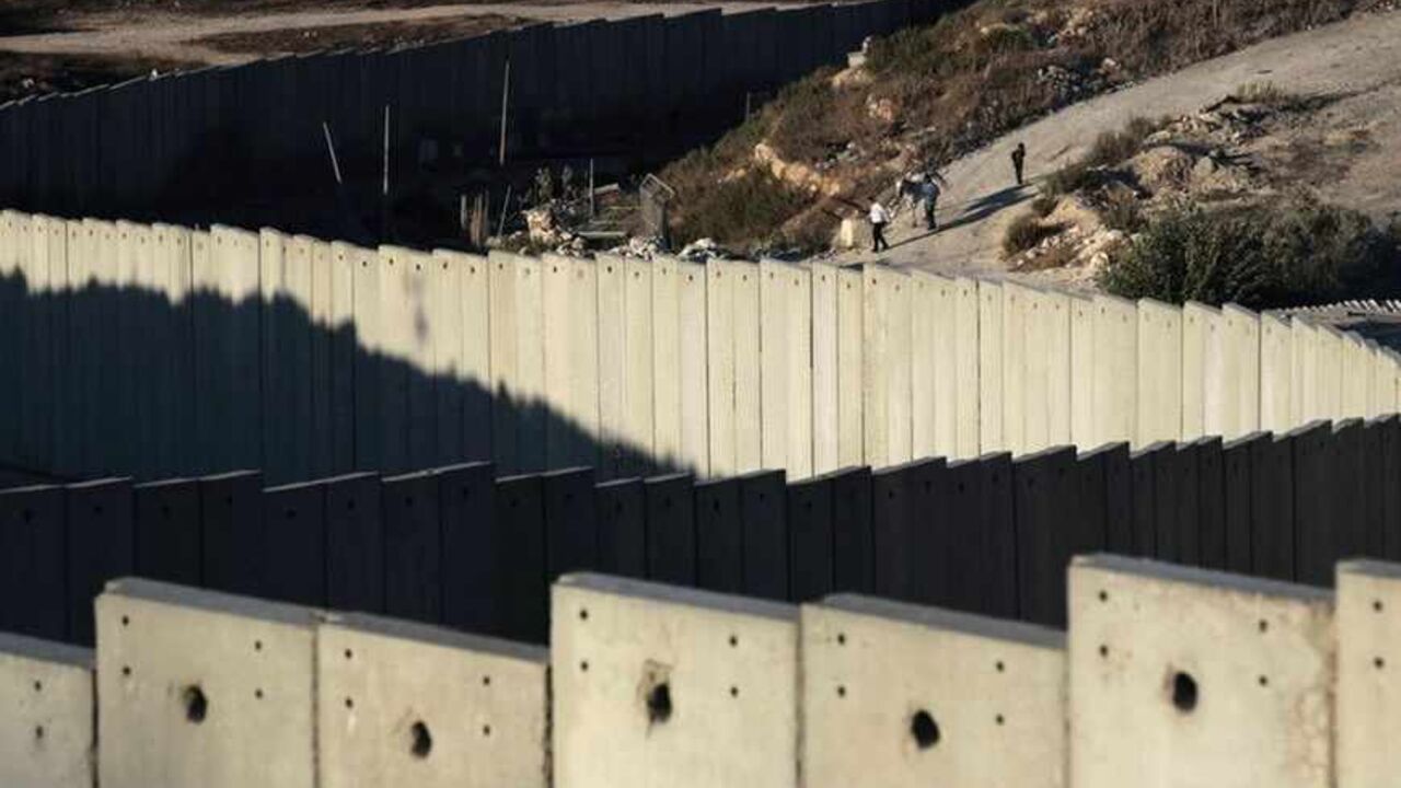 A section of the controversial Israeli barrier snakes around Shuafat refugee camp (R) in the West Bank near Jerusalem July 27, 2013. Israeli and Palestinian officials put forward clashing formats for peace talks due to resume in Washington on Monday for the first time in nearly three years after intense U.S. mediation. It is unclear how the United States hopes to bridge the core issues in the dispute, including borders, the future of Jewish settlements on the West Bank, the fate of Palestinian refugees and 