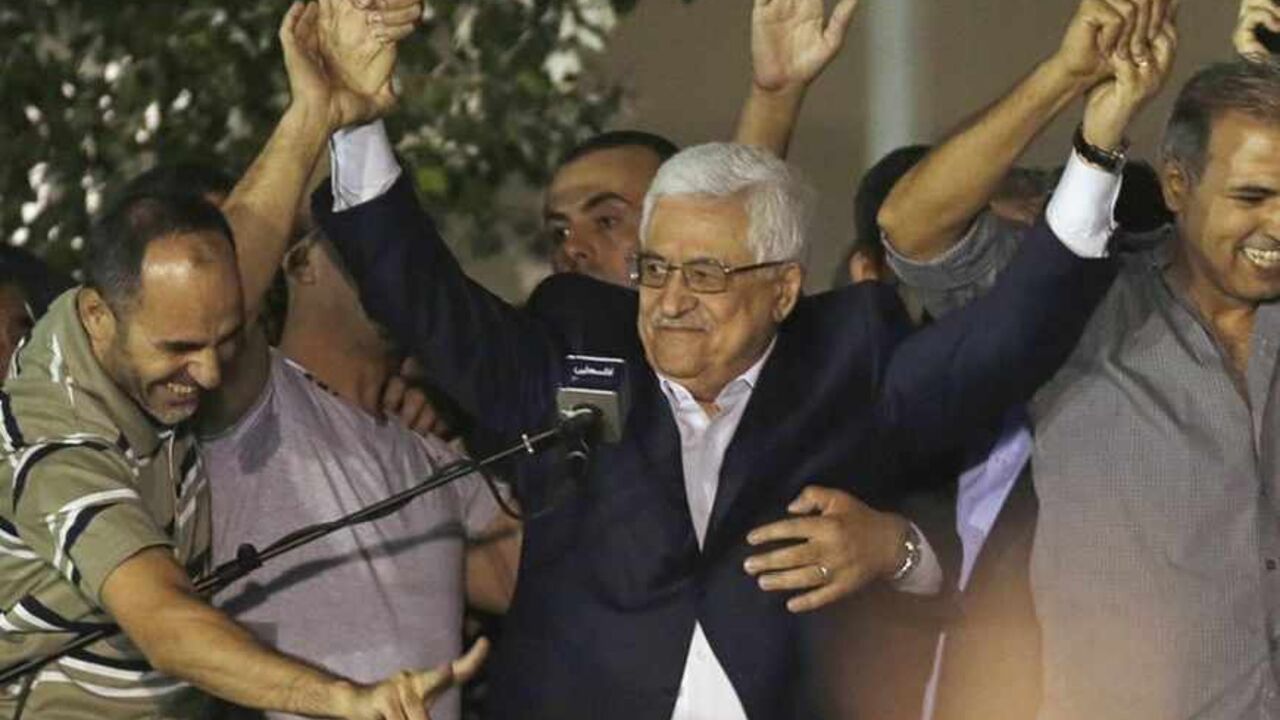Palestinian President Mahmoud Abbas (C) holds hands with Palestinian prisoners who were released from Israeli prisons during celebrations in the West Bank city of Ramallah early August 14, 2013. Israel freed 26 Palestinian prisoners on Wednesday to keep U.S.-sponsored peacemaking on course for a second round of talks, but diplomacy was dogged by Israeli plans for more Jewish homes on occupied land the Palestinians claim for a future state. REUTERS/Mohamad Torokman (WEST BANK - Tags: POLITICS TPX IMAGES OF T