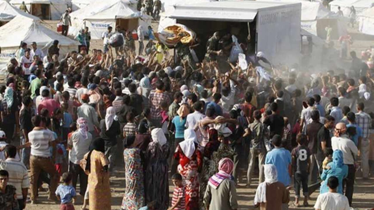Syrian refugees, who fled violence in Syria, are seen at a new refugee camp on the outskirts of the city of Arbil, in Iraq's Kurdistan region, August 20, 2013.  The government of Iraqi Kurdistan has set an entry quota of 3,000 refugees a day to cope with an influx of Kurds fleeing the civil war in Syria, but there are signs many more are still coming in, aid agencies said on Tuesday.  REUTERS/Thaier al-Sudani (IRAQ - Tags: POLITICS CIVIL UNREST SOCIETY IMMIGRATION) - RTX12RQY