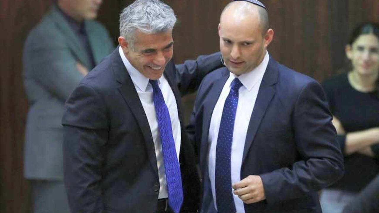 Israel's Finance Minister Yair Lapid (L) and Minister of Economics and Trade Naftali Bennett (2nd L) walk together during the swearing-in ceremony, at the Knesset, the Israeli Parliament, in Jerusalem March 18, 2013. Israeli Prime Minister Benjamin Netanyahu's new governing coalition took office after a parliamentary vote on Monday with powerful roles reserved for supporters of settlers in occupied territory. REUTERS/Baz Ratner (JERUSALEM - Tags: POLITICS) - RTR3F5XP
