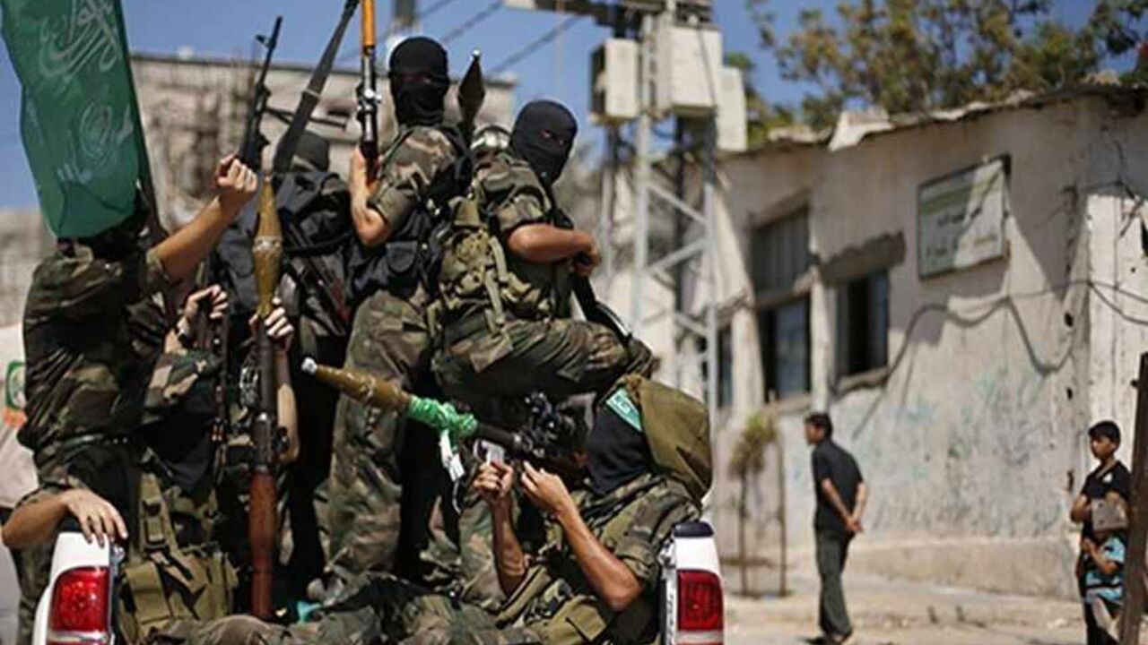 Boys watch as Palestinian militants on a truck protest against peace talks between Israel and the Palestinians, as well as possible U.S. attacks on Syria, in the northern Gaza Strip September 6, 2013. The protest was organized by Hamas militants and other Palestinian factions. REUTERS/Suhaib Salem (GAZA - Tags: POLITICS CIVIL UNREST) - RTX139GR