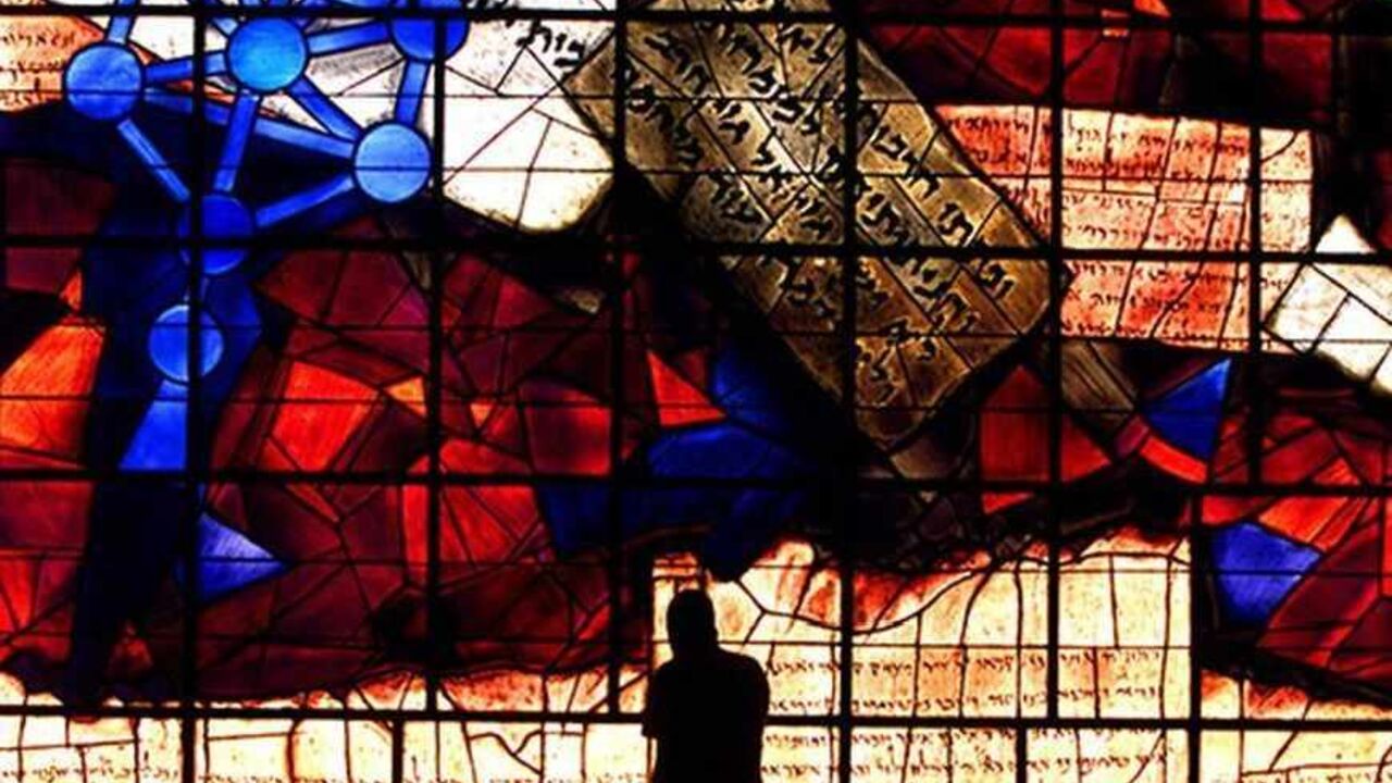 A student uses his mobile phone during a break as he is silhouetted against the "Ardon Windows? in the library of the Hebrew University of Jerusalem June 3, 2002. The Ardon windows are Isaiah's vision of eternal peace in a triptych by artist Mordecal Ardon. The part of the triptych in the photo focuses on Jerusalem, in the lower section the city wall is represented as the Dead Sea Scroll of the book of Isaiah. Above the wall a piece of parchment carries part of the Prophecy, "and they shall beat their sword