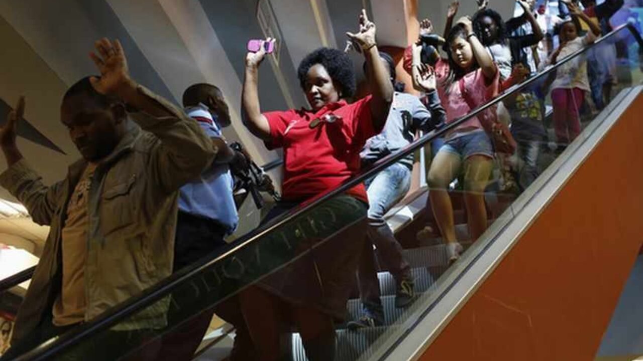 Civilians escape an area at the Westgate Shopping Centre in Nairobi September 21, 2013. Gunmen stormed the shopping mall in Nairobi on Saturday killing at least 20 people in what Kenya's government said could be a terrorist attack, and sending scores fleeing into shops, a cinema and onto the streets in search of safety. Sporadic gun shots could be heard hours after the assault started as soldiers surrounded the mall and police and soldiers combed the building, hunting down the attackers shop by shop.  REUTE