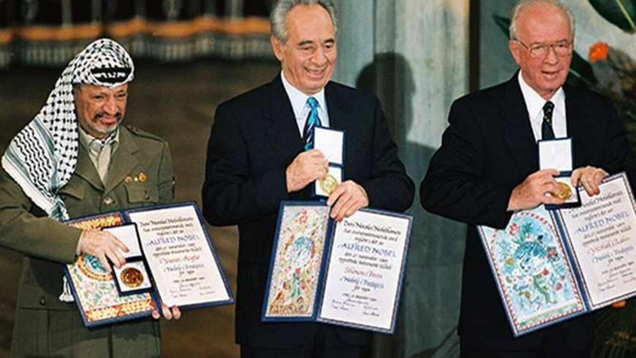 File photograph of Palestinian President Arafat, Israel's Perez and Israeli Prime Minister Rabin showing their Nobel Peace Prize in Oslo.  Palestinian President Yasser Arafat was in a coma and in critical condition in the intensive care unit at a French military hospital after his health suddenly deteriorated, aides said November 4, 2004. Palestinian President Yasser Arafat, (L) Israel's Shimon Perez (C) and Israeli Prime Minister Yitzhak Rabin show their Nobel Peace Prize in Oslo in this December 10, 1994 