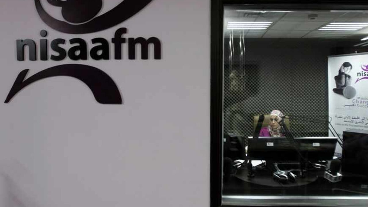 A radio broadcaster sits in the sound booth at NISAA FM radio station in the West Bank city of Ramallah July 9, 2012. Looking to spread the good word, NISAA FM radio station took to the airwaves in 2010, set up by and for women. It highlights local success stories about anything from female-led investment groups to refugee camp microfinance projects. Picture taken July 9, 2012. To match story PALESTINIAN-BUSINESS/WOMEN  REUTERS/Mohamad Torokman (WEST BANK - Tags: BUSINESS MEDIA) - RTR34TV0