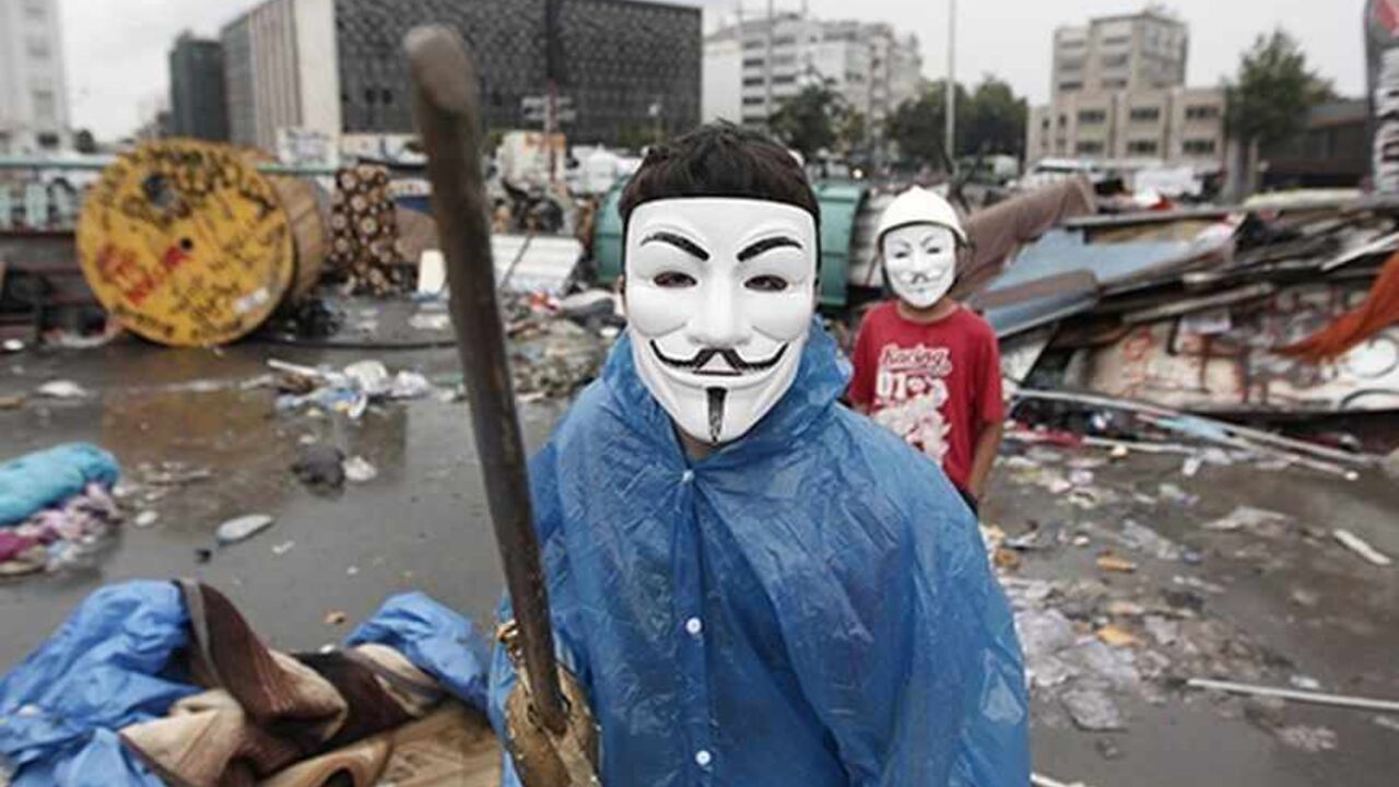 A boy wearing a Guy Fawkes mask displays his wooden sword behind a barricade at Gezi Park in central Istanbul June 12, 2013. Turkish riot police fought running battles with pockets of protesters overnight, clearing the central Istanbul square that has been the focus of nearly two weeks of protests against Turkey's prime minister. By dawn, Taksim Square, strewn with wreckage from bulldozed barricades, was largely deserted and taxis crossed it for the first time since the troubles started. Several hundred rem
