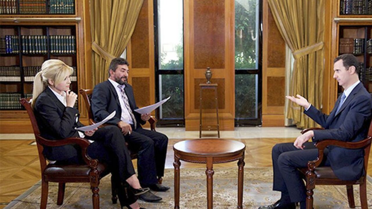 Syria's President Bashar al-Assad (R) speaks during an interview with Turkey's Halk TV in Damascus, in this handout photograph distributed by Syria's national news agency SANA on October 4, 2013. Assad has told Turkey it will pay a heavy price for backing rebels fighting to oust him, accusing it of harbouring "terrorists" along its border who would soon turn against their hosts. In an interview with Turkey's Halk TV due to be broadcast later on Friday, Assad called Turkish Prime Minister Tayyip Erdogan "big