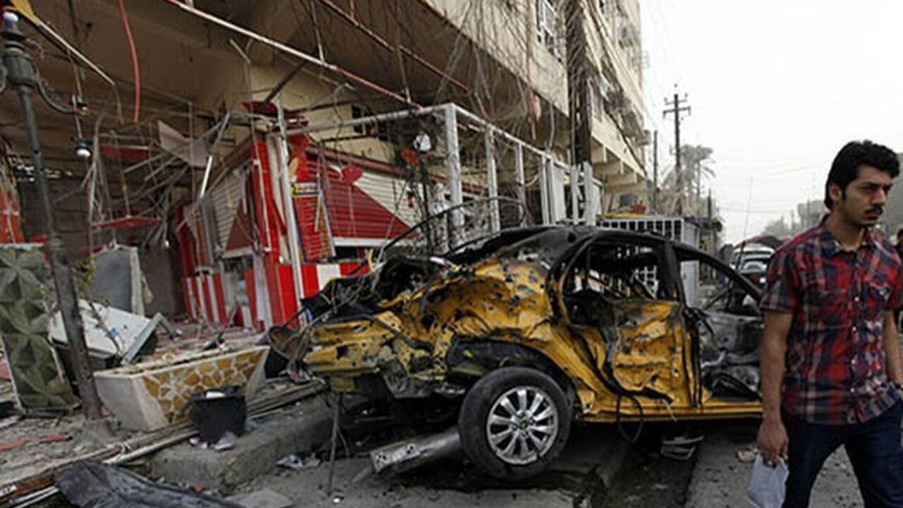 A man walks past the site of a car bomb attack outside an ice cream parlour in the Al-Mashtal district in Baghdad, October 19, 2013. At least five people were killed in the attack and 15 others were wounded, police said.  REUTERS/Thaier Al-Sudani (IRAQ - Tags: CIVIL UNREST CRIME LAW TPX IMAGES OF THE DAY) - RTX14GKJ