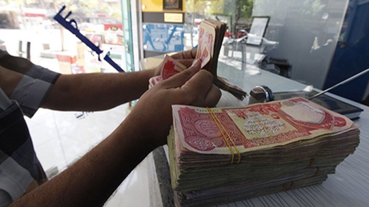 A customer counts Iraqi dinars at a money changer in Baghdad October 1, 2012. Many Iraqis have lost faith in their dinar currency but to some foreign speculators, it promises big profits. The contrast underlines the uncertainties of investing in Iraq as the country recovers from years of war and economic sanctions. Picture taken October 1, 2012. To match IRAQ-ECONOMY/DINAR  REUTERS/Saad Shalash (IRAQ - Tags: BUSINESS POLITICS) - RTR38QU1
