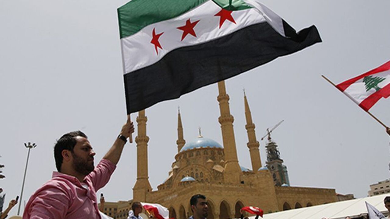 Anti-Hezbollah activists wave Syrian opposition (L) and Lebanese national flags during a protest in Beirut June 9, 2013. A Lebanese protester was killed outside the Iranian embassy in Beirut on Sunday after gunmen from the Iranian-backed Shi'ite militia Hezbollah opened fire when anti-Hezbollah Shi'ite demonstrators approached, witnesses and officials said.               REUTERS/Jamal Saidi                   (LEBANON - Tags: CIVIL UNREST POLITICS) - RTX10H9O