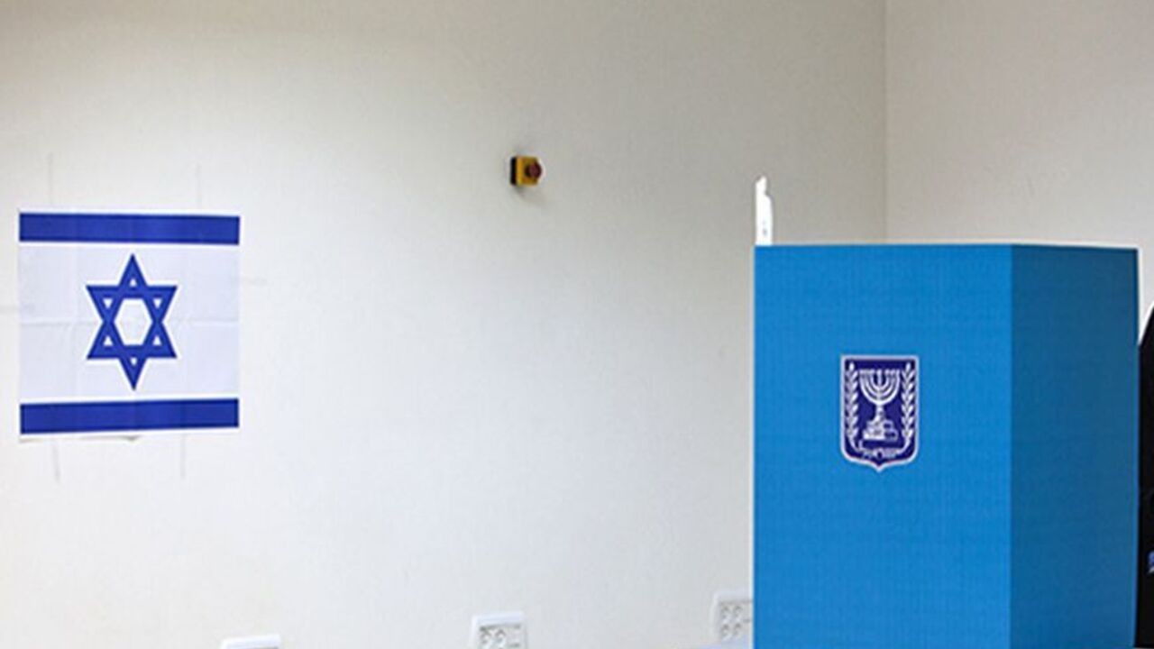 An Israeli Arab woman stands behind a booth as she casts her ballot for the parliamentary election at a polling station in the town of Tira January 22, 2013. Israelis voted on Tuesday in an election that is expected to see Prime Minister Benjamin Netanyahu win a third term in office, pushing the Jewish state further to the right, away from peace with the Palestinians and towards a showdown with Iran. REUTERS/Nir Elias (ISRAEL - Tags: POLITICS ELECTIONS TPX IMAGES OF THE DAY) - RTR3CSL6
