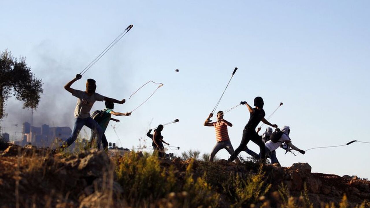 Palestinian protesters hurl rocks at Israeli soldiers during clashes in Betunia, near the West Bank city of Ramallah October 11, 2013. REUTERS/Mohamad Torokman (WEST BANK - Tags: POLITICS CIVIL UNREST TPX IMAGES OF THE DAY) - RTX147KO