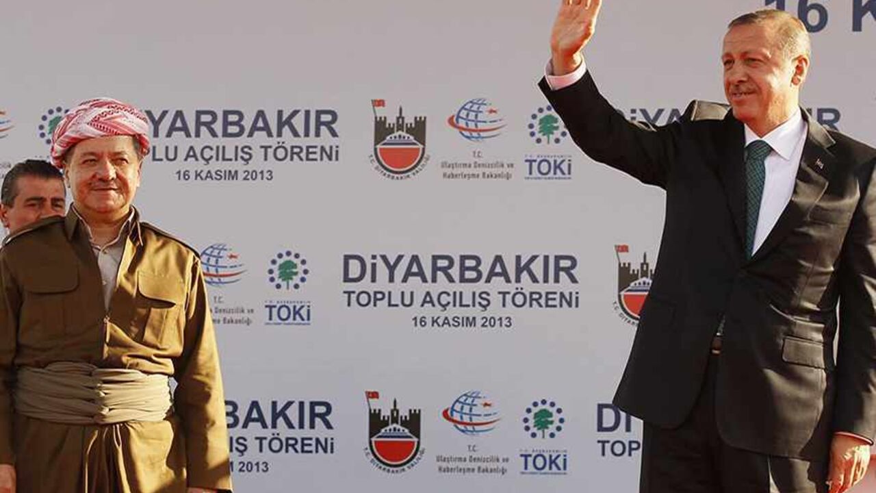 Turkey's Prime Minister Tayyip Erdogan (R) and President of Iraqi Kurdistan Masoud Barzani greet people during a ceremony in Diyarbakir November 16, 2013.  The president of Iraqi Kurdistan called on Turkey's Kurds to back a flagging peace process with Ankara on Saturday, making his first visit to southeastern Turkey in two decades in a show of support for PM Erdogan. Barzani's trip to Diyarbakir, the main city in Turkey's Kurdish-dominated southeast, comes as Ankara finalises billions of dollars of energy d