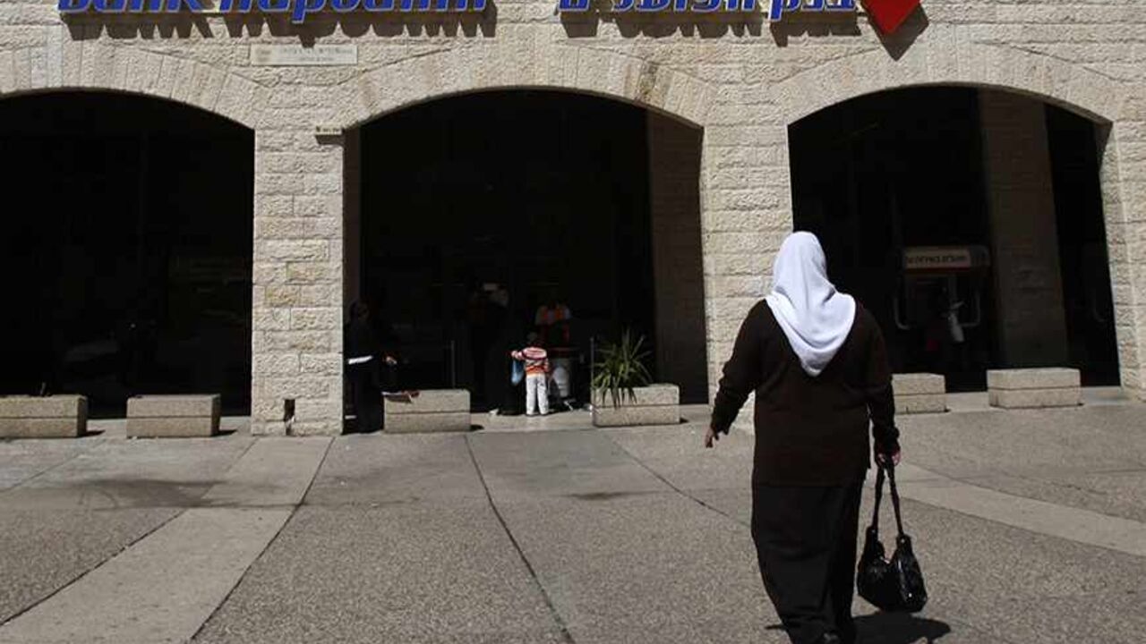 A pedestrian walks outside a branch of Bank Hapoalim in Jerusalem March 26, 2009. Bank Hapoalim, Israel's largest lender in terms of assets, should return to profitability in the first quarter after posting a loss in the 
fourth quarter, its chairman said on Thursday. 
REUTERS/Baz Ratner (JERUSALEM BUSINESS) - RTXD7YQ