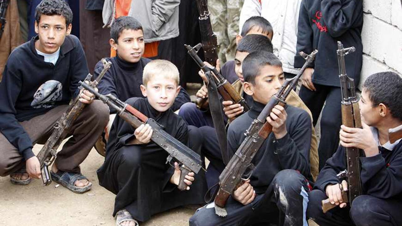 Boys carry weapons during a weapon handover event to the Iraqi government in Basra, 420 km (260 miles) southeast of Baghdad December 11, 2010. Several Iraqi tribes handed over their weapons, acquired during the Saddam Hussein era, to the Iraqi government, as part of a security plan to improve the security situation in southern Iraq. Picture taken December 11, 2010. REUTERS/Atef Hassan (IRAQ - Tags: POLITICS) - RTXVNSE