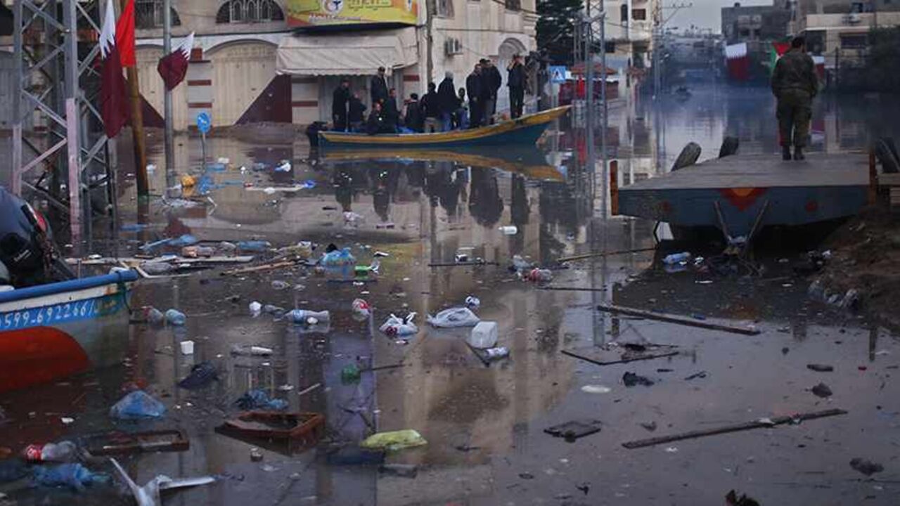 Palestinians ride a boat at a neighborhood flooded with rainwater in the northern Gaza Strip December 17, 2013. Four days of torrential rains in Gaza Strip killed two people and forced the evacuation of more than 5,000 residents from flooded homes, some accessible only by boat, officials said. REUTERS/Mohammed Salem (GAZA - Tags: ENVIRONMENT SOCIETY) - RTX16MGK